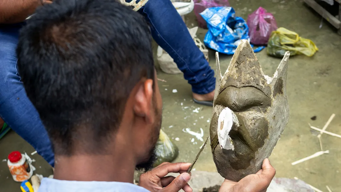 Talla de una pieza de piedra clara con herramienta de mano sobre un banco de taller